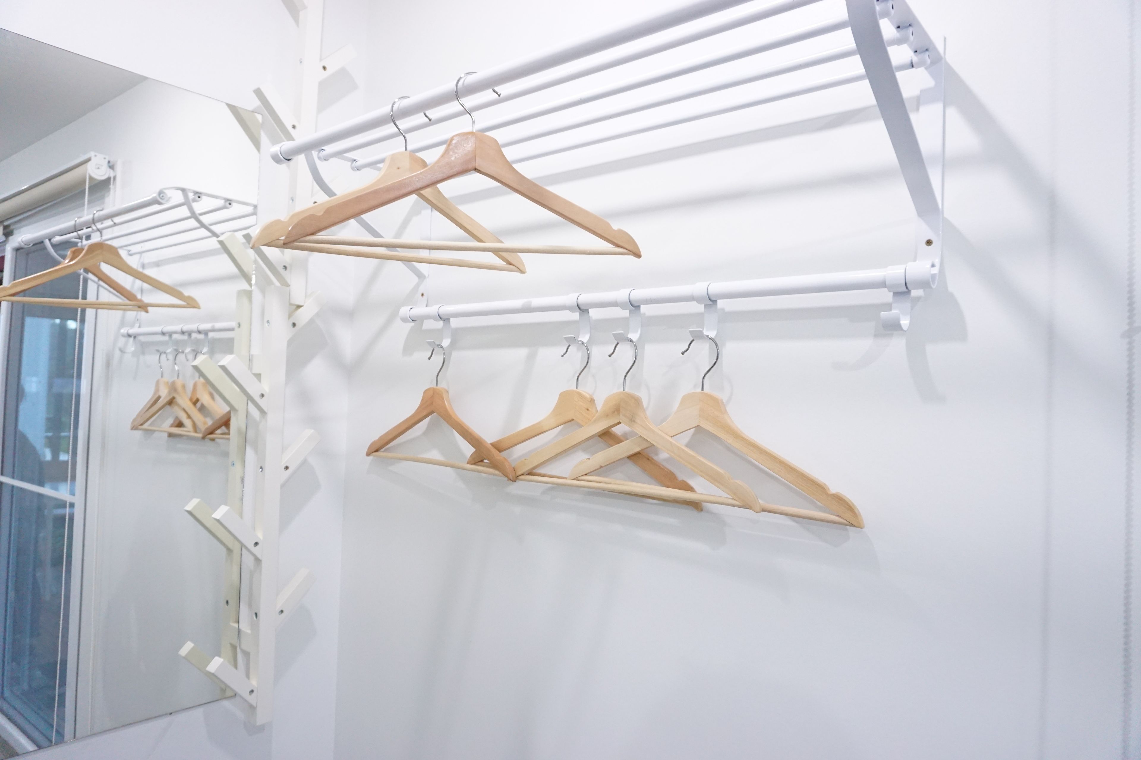 Un tendedero de pared con perchas de madera.