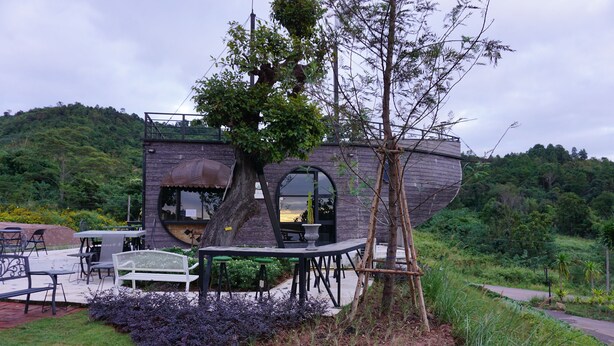 A house with a unique boat-like structure, outdoor seating, and a garden area. - Phu Sumphao Valley (Phu Ruea)