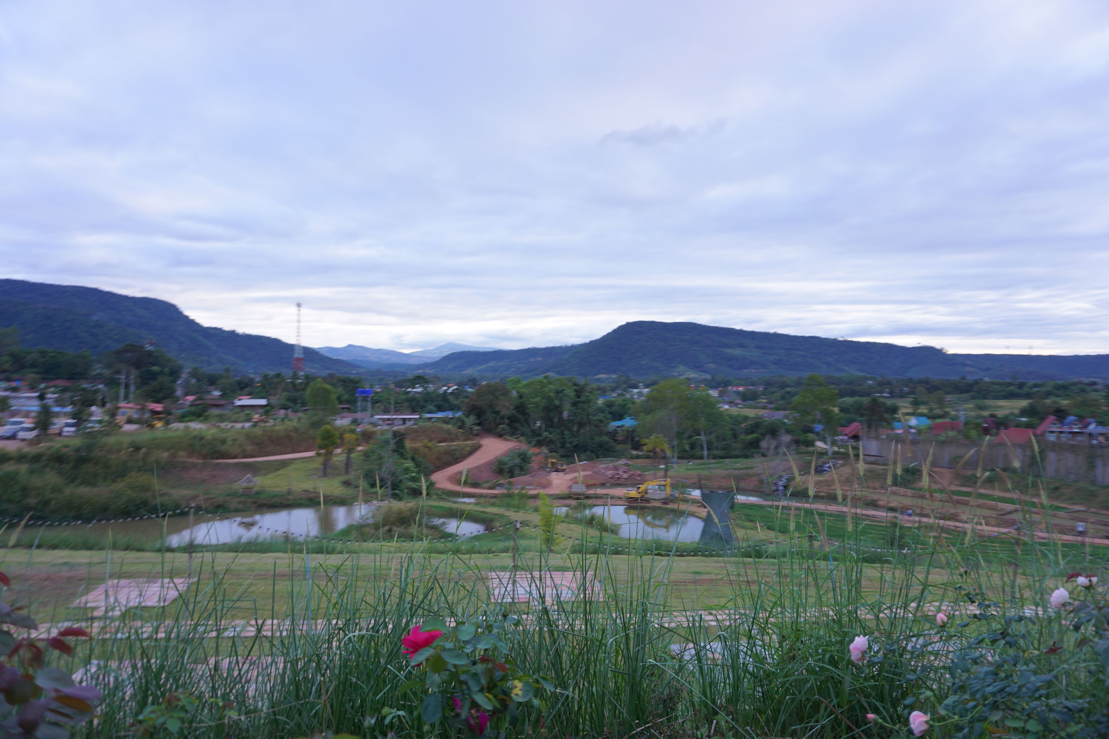 A rural landscape with a river, fields, and distant hills.