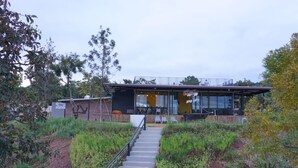 A modern building with a staircase leading to a covered outdoor area. - Phu Sumphao Valley (Phu Ruea)