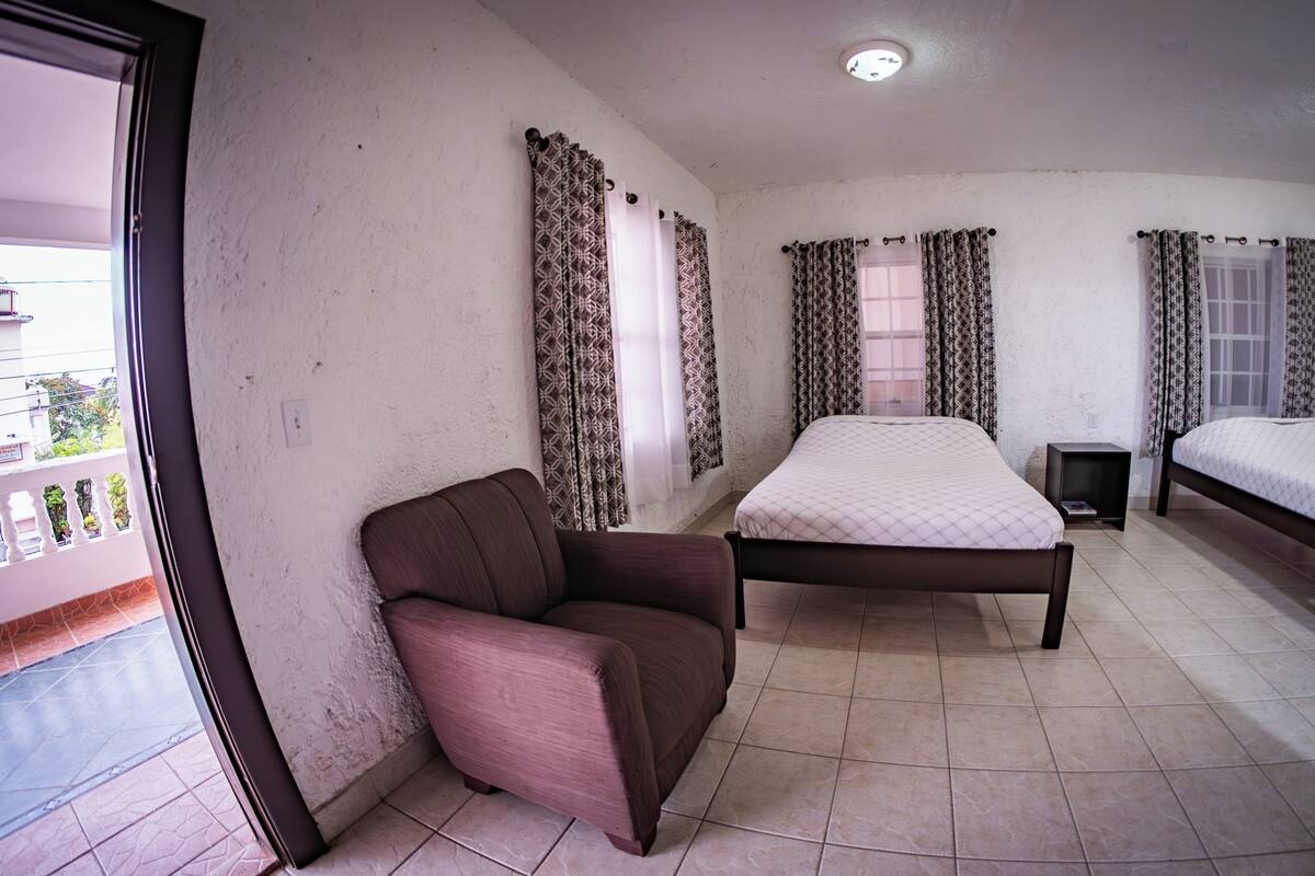 Une chambre avec deux lits, une chaise et une petite table.
