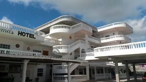 A multi-story hotel with balconies and a central staircase. - Las Palmas Hotel (Corozal)