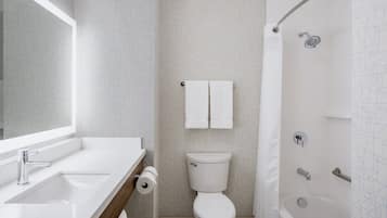 Un baño moderno con lavamanos, inodoro y ducha.
