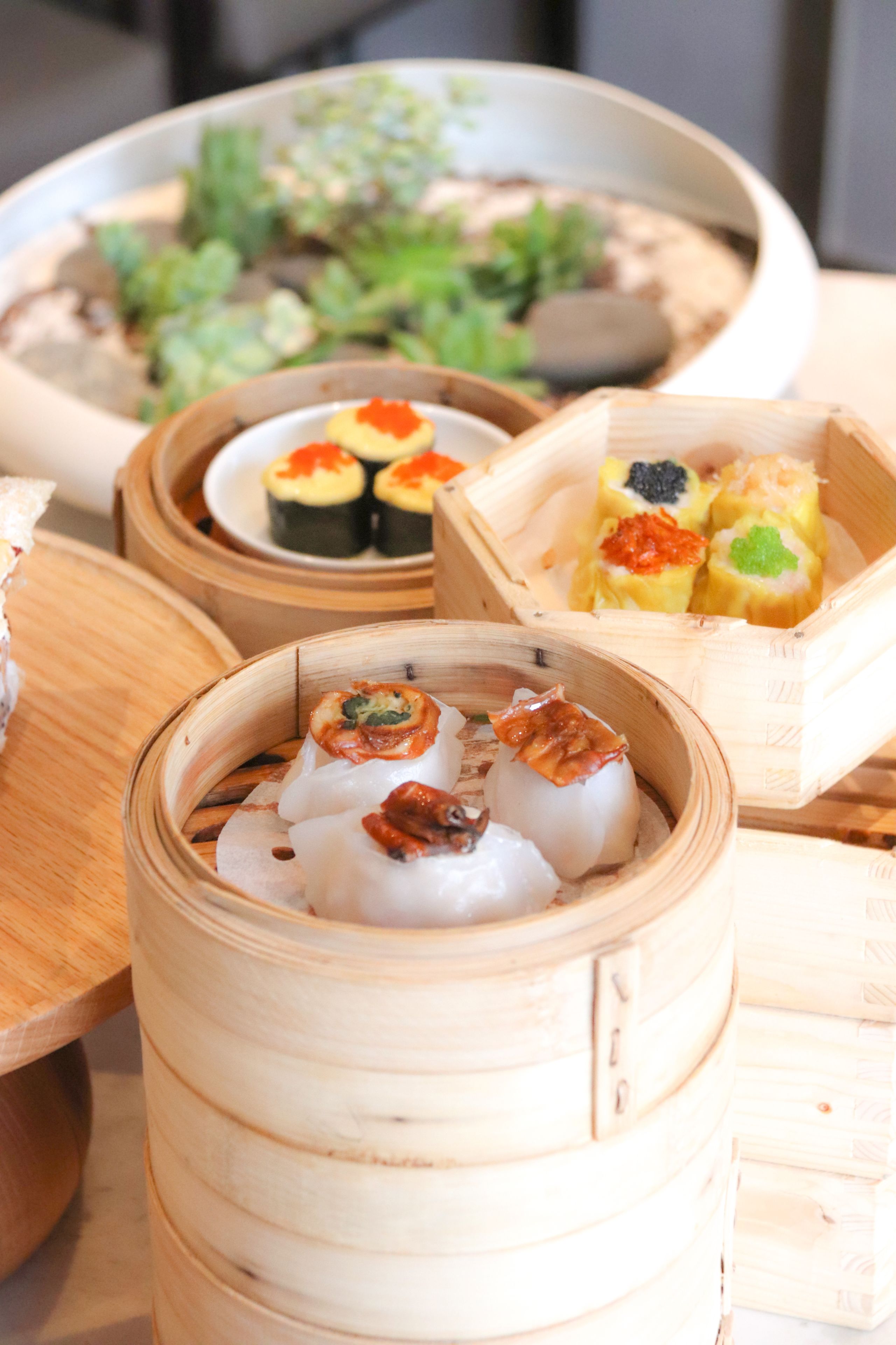 A variety of sushi and other Asian dishes served in bamboo steamers.