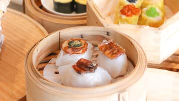 A variety of sushi and other Asian dishes served in bamboo steamers.