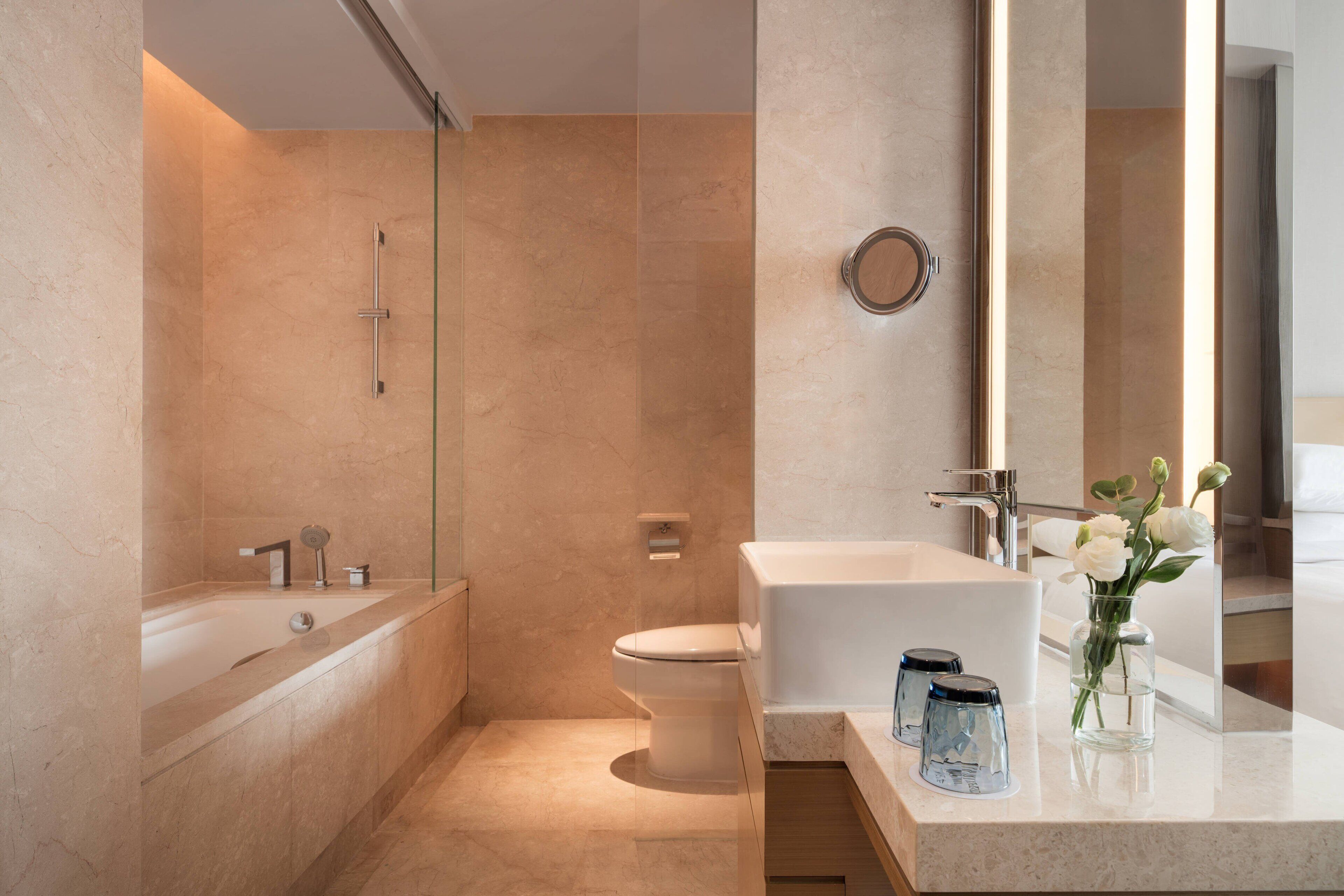 A modern bathroom with a bathtub, toilet, and sink.