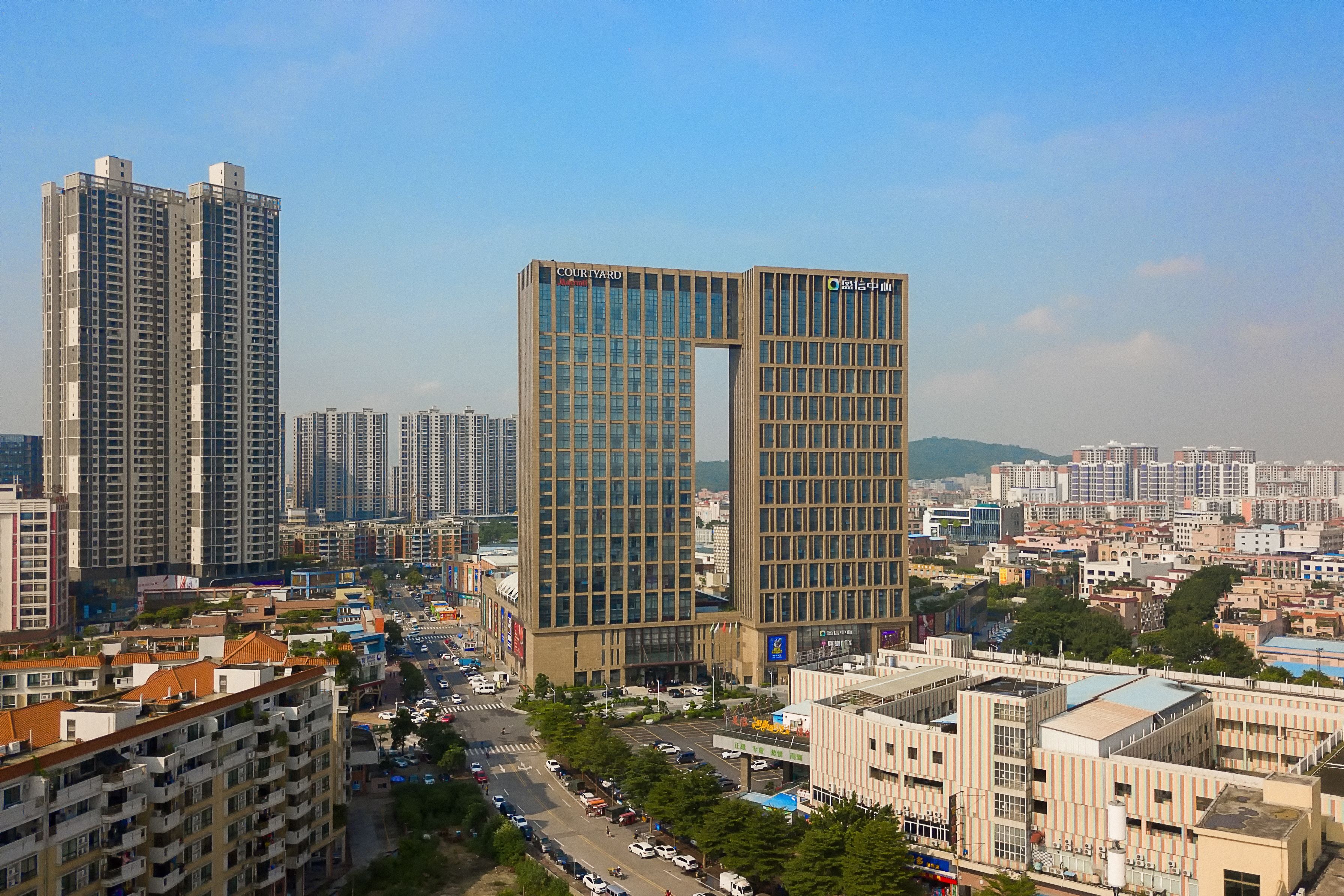 A high-rise building with a modern design, featuring a prominent vertical section and multiple floors.