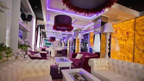 A luxurious living room with plush sofas, a coffee table with a decorative centerpiece, and a marble accent wall. - Harmony Palace (Burgas)