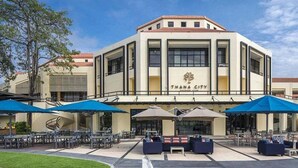Un hotel con entrada principal, zona de estar al aire libre y cielo despejado.
