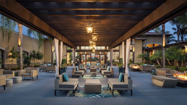A covered outdoor seating area with wicker furniture and a central fire feature. - Westin Carlsbad Resort & Spa (Carlsbad)