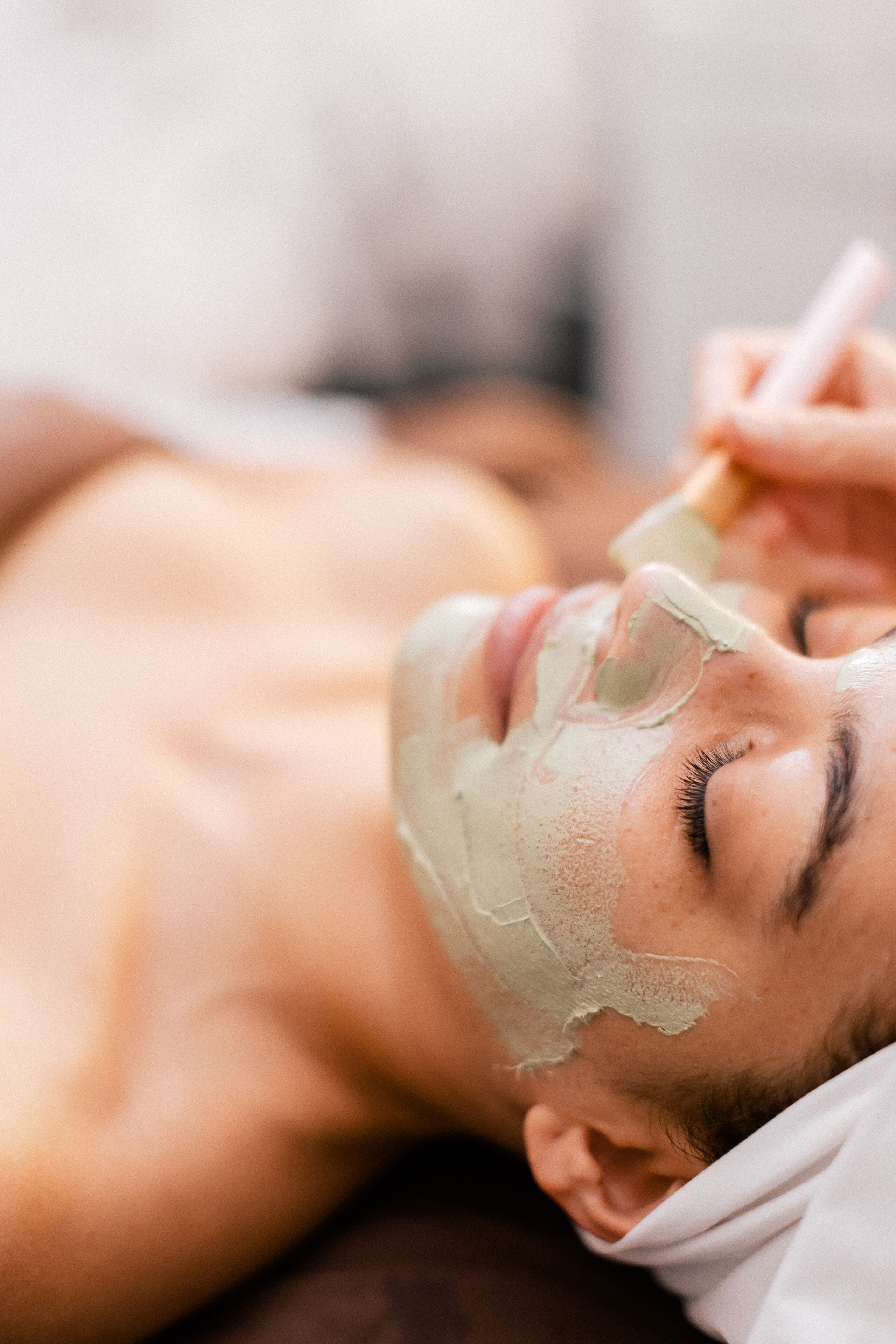 A person receiving a facial treatment with a mask.