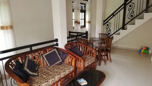A living room with a sofa set, a coffee table, and a staircase. - Abha Villa (Galle)