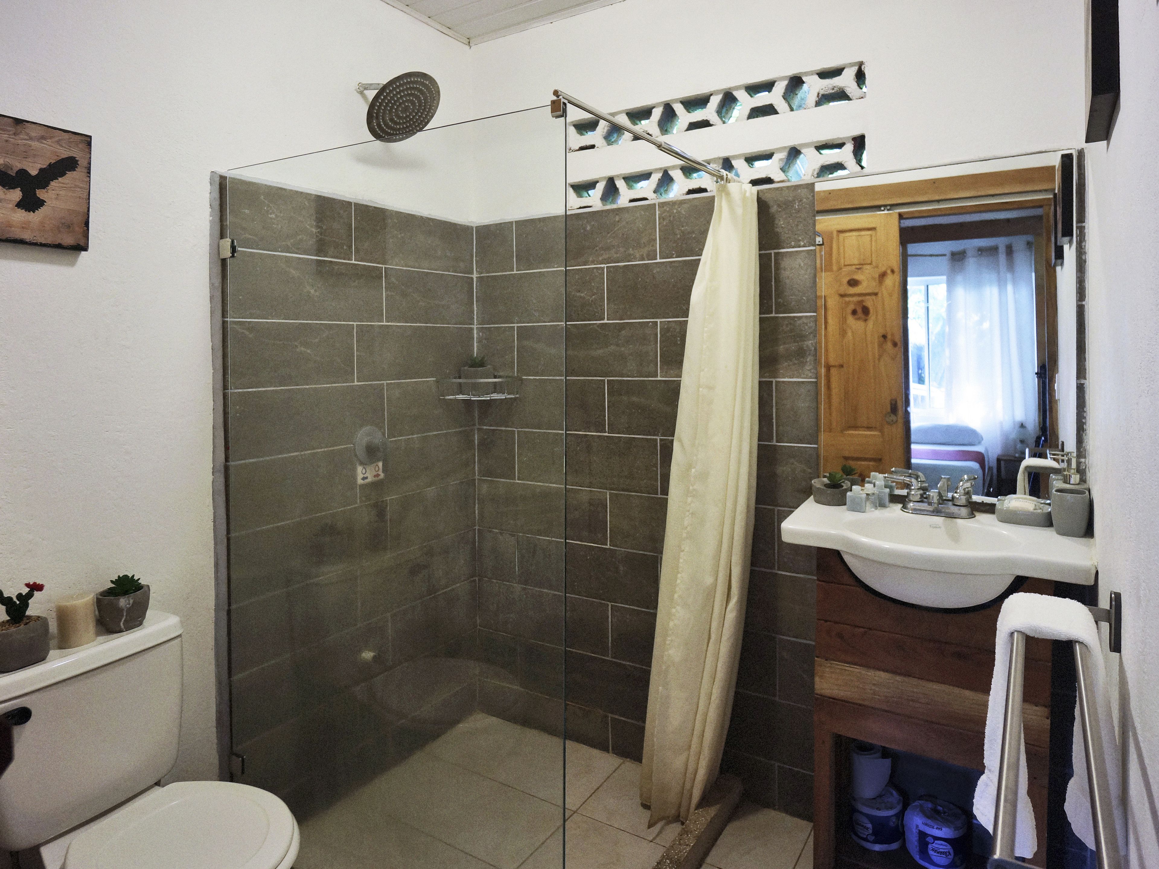 A bathroom with a shower, toilet, and sink.