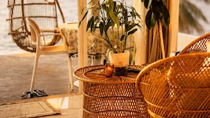 A room with a view of the ocean, wicker furniture, a hanging chair, and a potted plant. - Bintana Sa Paraiso (Mambajao)