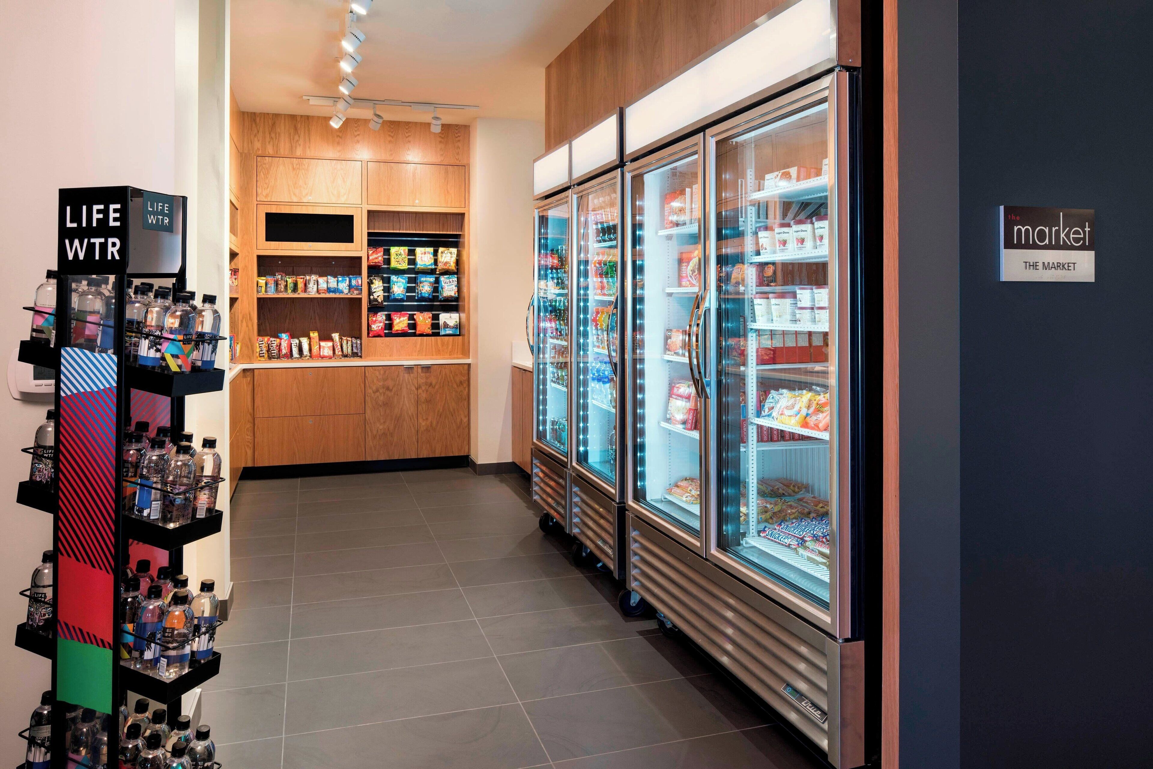 A modern grocery store with refrigerated display cases and a variety of products on shelves.