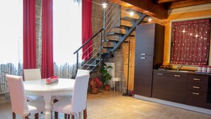 Una cucina con zona pranzo, una scala e vista esterna.