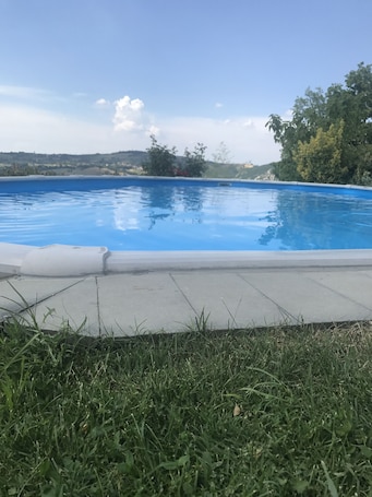 Una piscina al aire libre, sillones reclinables de piscina