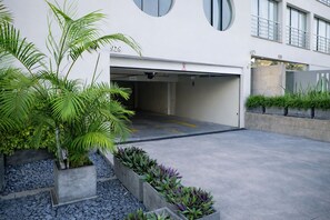 Un bâtiment moderne doté d’un accès au garage, portant le numéro 928, et d’un espace paysager agrémenté de plantes et de gravier.
