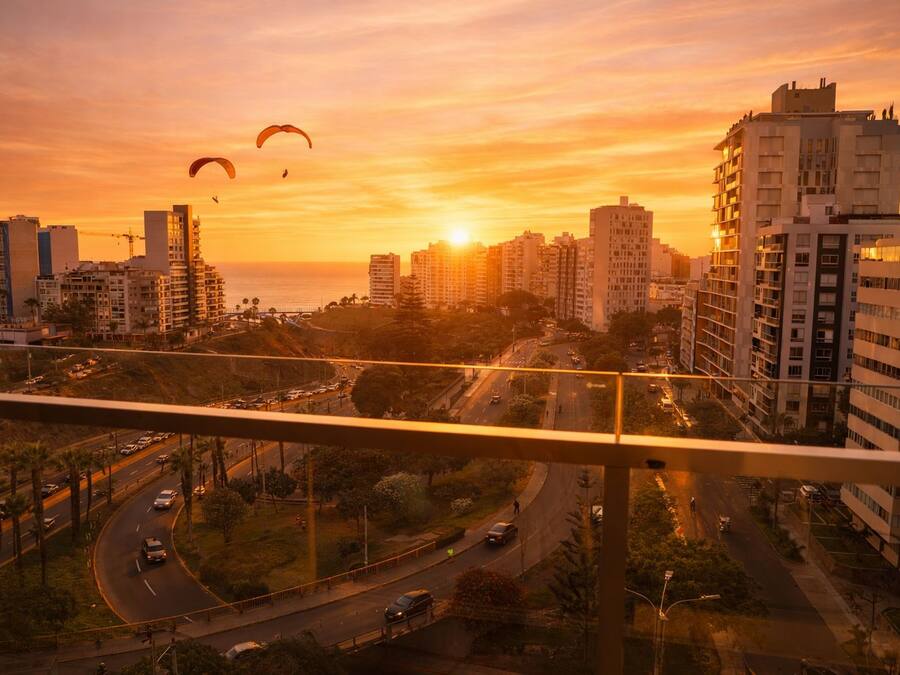 Un paisaje urbano con rascacielos, un puente y una puesta de sol.