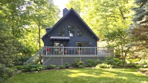 A cabin with a porch, surrounded by trees. - Garden Cottage 2.5 Miles to Downtown With Private, Wooded Surroundings (Asheville)