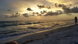 Een strand met golven en een zonsondergang.