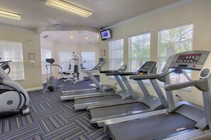 A gym with treadmills, exercise bikes, and weight machines.