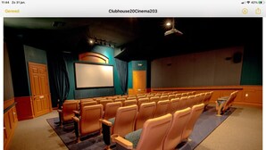 Un cine con hileras de asientos, una pantalla grande y un escenario.