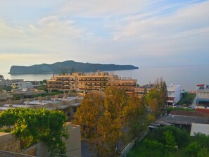 A coastal residential area with modern buildings, a view of the sea, and a distant mountain. - Rubini Home III 3 minutes from sea by feet (Chania)