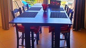 A dining table with chairs, a vase with flowers, and a view of the sea and greenery. - Rubini Home III 3 minutes from sea by feet (Chania)