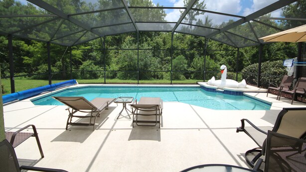 Una piscina exterior techada con sillas de descanso y un jacuzzi.