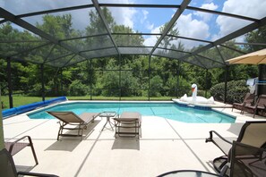 Une piscine extérieure couverte, dotée de chaises longues et d’un jacuzzi.
