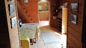 A wooden interior with a dining area, a kitchen, and a storage cabinet.