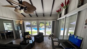 A sunroom with a pool view, a ceiling fan, and a laptop on a table. - Ft. Myers-Labelle-Okeechobee Clewiston WiFi  Pool Vacation Home. (LaBelle)