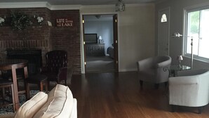 Ein großzügiges Wohnzimmer mit Kamin, einer Couch und einem Essbereich mit Tisch und Stühlen.