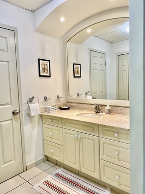 A bathroom with a large mirror, a sink, and a vanity with multiple drawers. - Beachfront Playa Royale Studio on one of the most prestigious sandy beaches (Nuevo Vallarta)