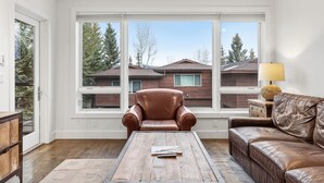 Un salon avec un fauteuil en cuir marron, un canapé en cuir marron et une table basse en bois.