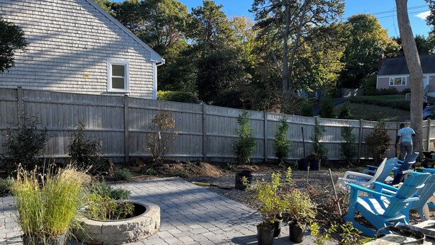 A backyard with a wooden fence, potted plants, and outdoor furniture. - 4 Bedrooms, 2 Baths, Sleeps 8-10 (Chatham)