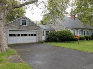 A two-story house with a garage, surrounded by a well-maintained lawn and trees. - 4 Bedrooms, 2 Baths, Sleeps 8-10 (Chatham)