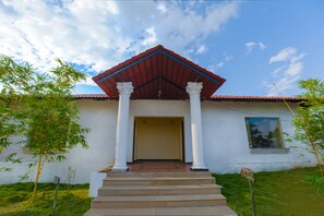Un bâtiment avec un toit rouge, des colonnes blanches et une enseigne portant le numéro « 312 ».