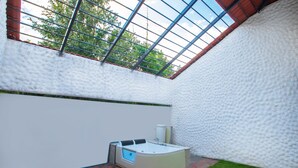 A spa area with a hot tub, a window, and a tiled floor. - Tuli Veer Bagh Resort (Ramtek)
