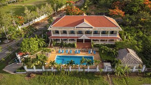 A large resort with a swimming pool, multiple balconies, and lush landscaping. - Riviera Hotel & Resort Kep (Kep)