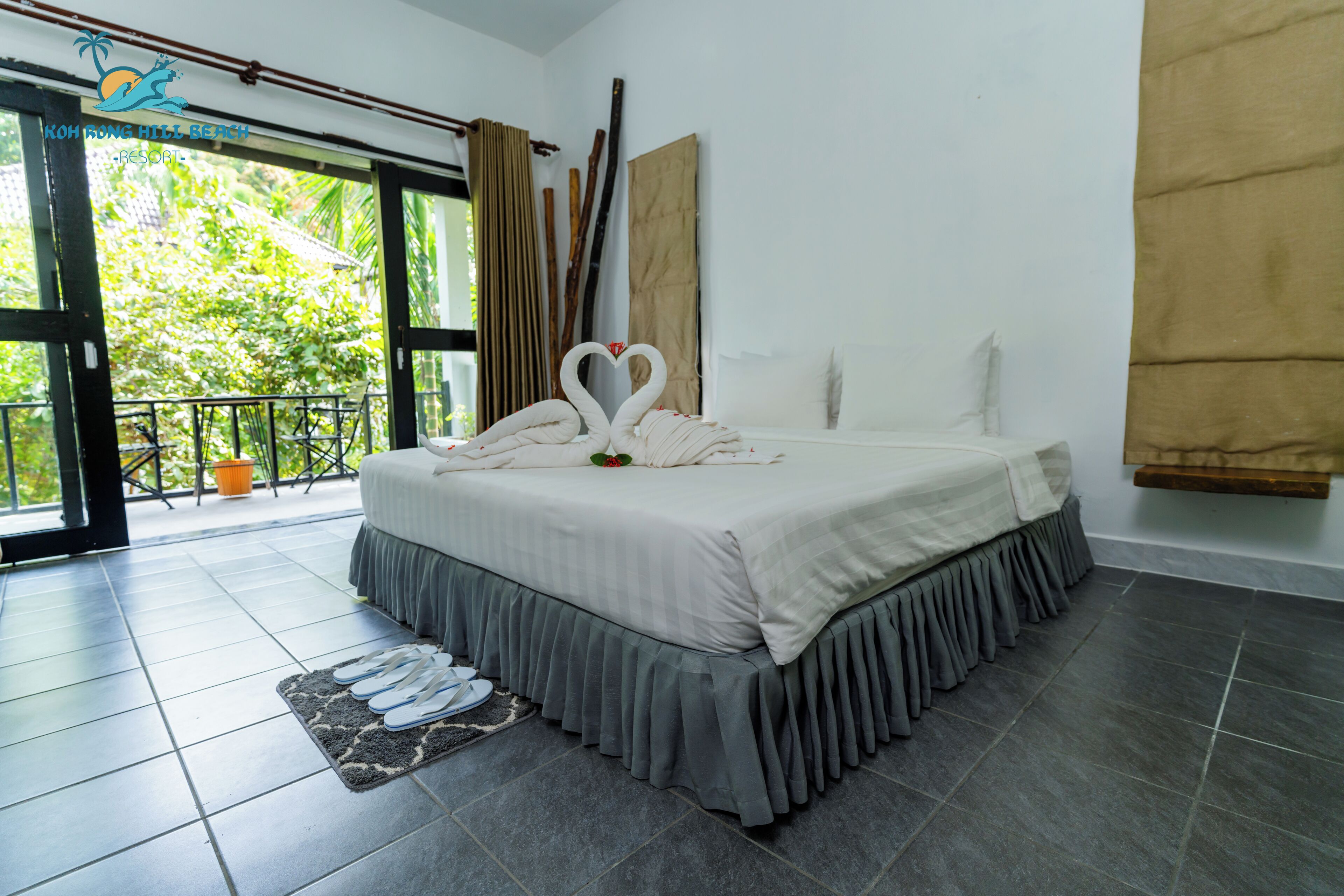 Une chambre d’hôtel avec un lit, une vue sur la verdure et un balcon doté d’une balustrade.