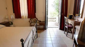 Une chambre à coucher avec un lit, une chaise, un bureau et une fenêtre avec des rideaux.