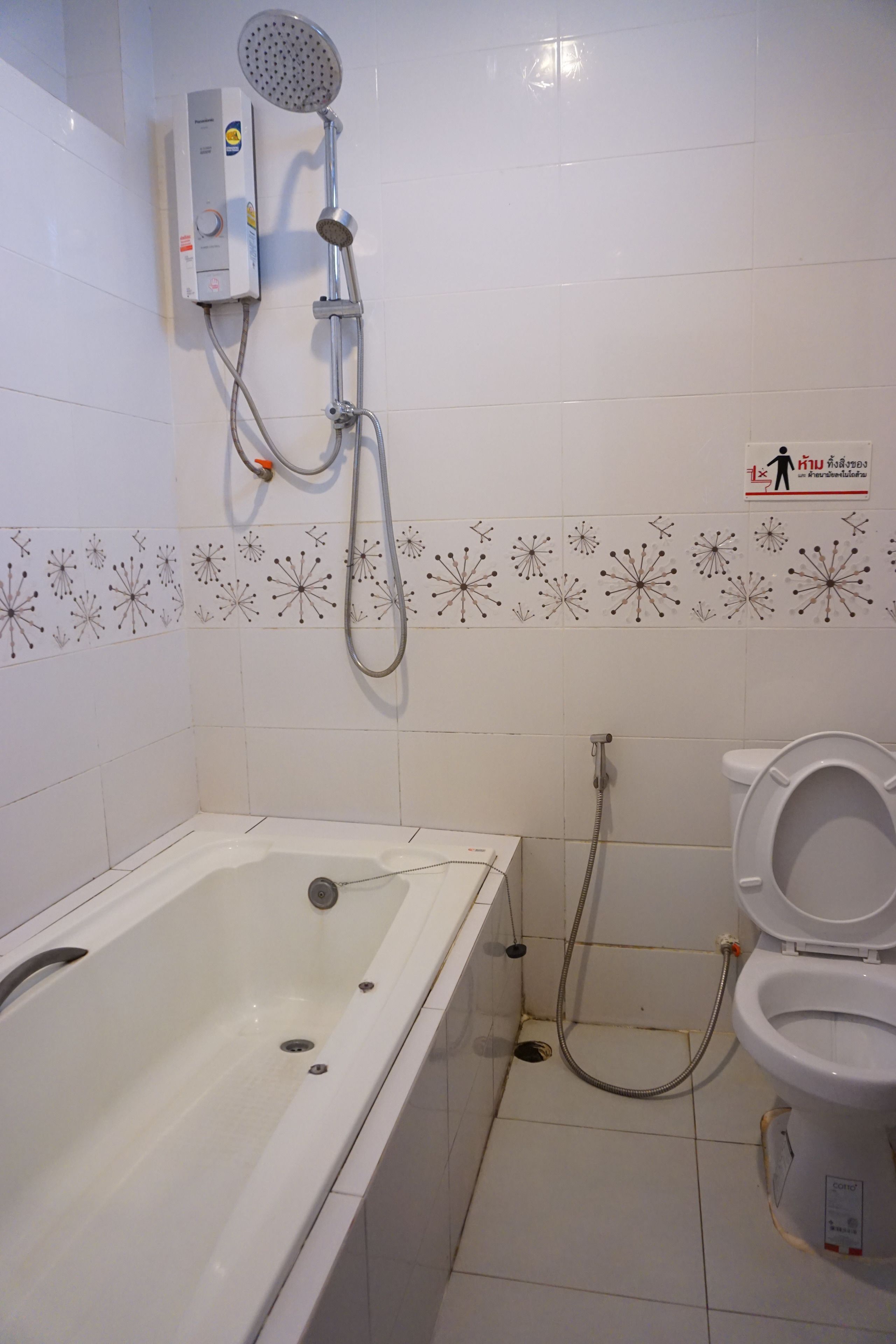 Een badkamer met een bad, toilet en douche.
