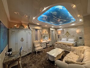 A luxurious bedroom with a large bed, ornate furniture, and a ceiling skylight. - Hotel Agava (Tbilisi)
