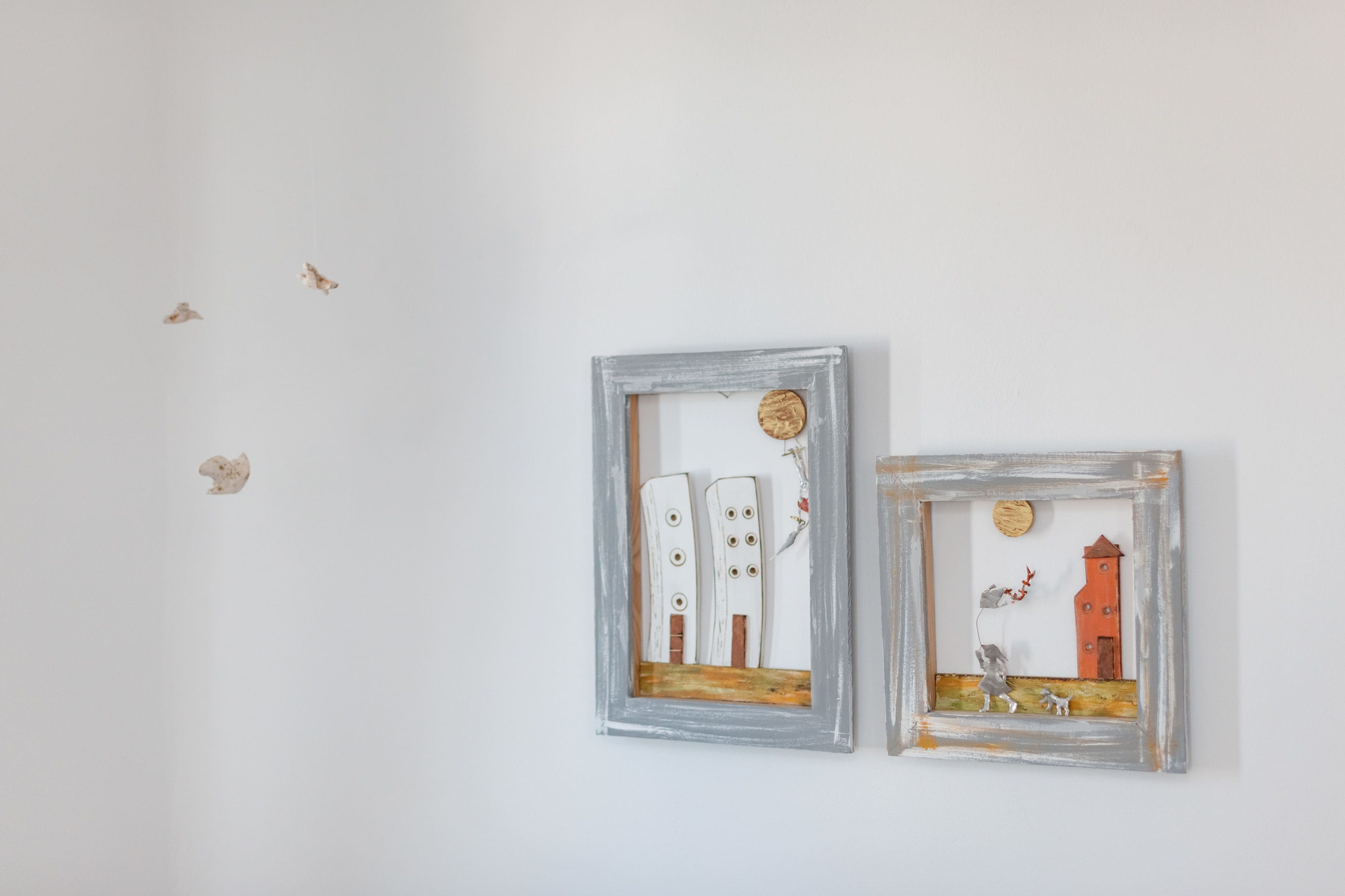 Two framed artworks on a plain wall.
