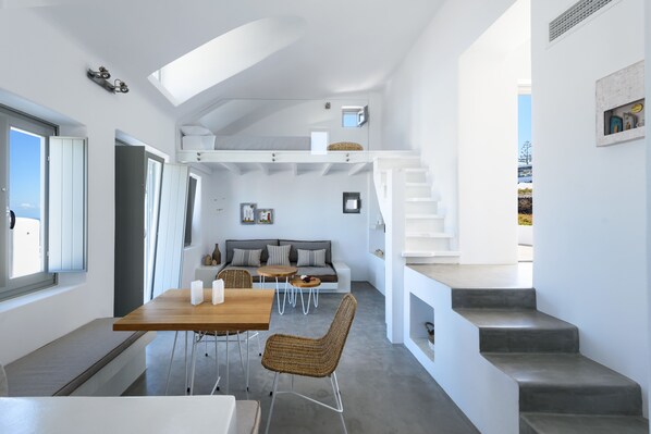 Un intérieur moderne comprenant un coin repas, un canapé et un escalier.
