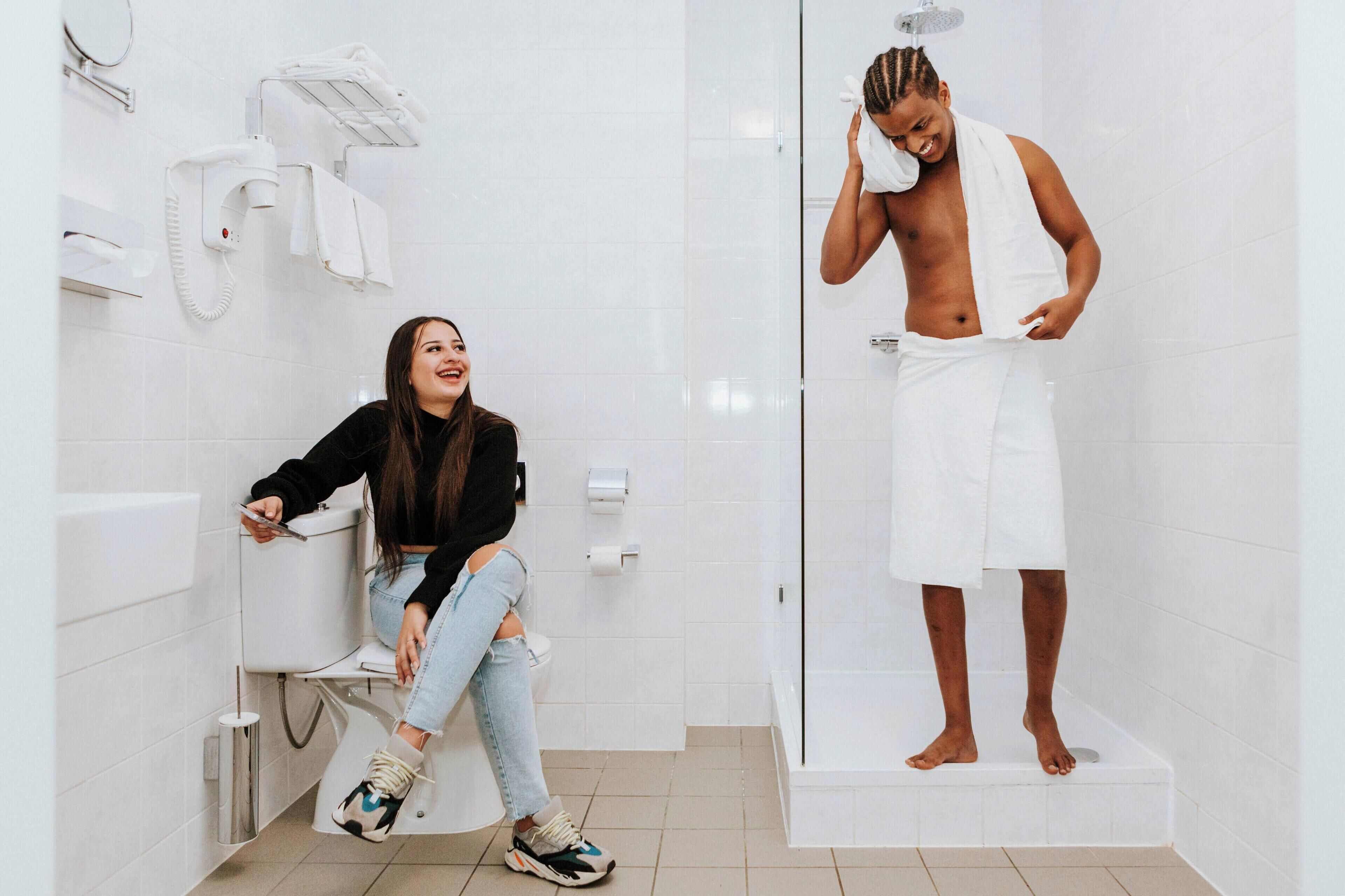 A bathroom with a toilet, a shower, and a hand dryer.
