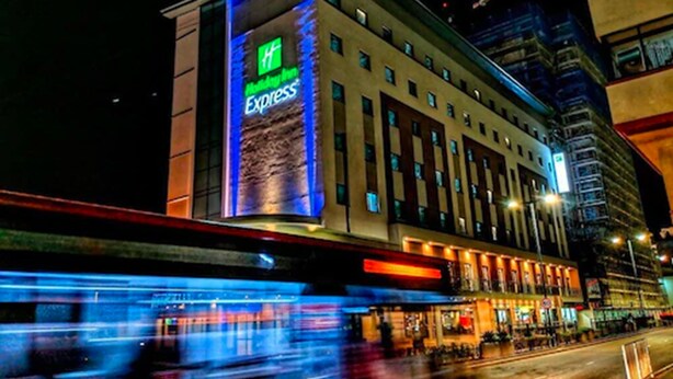 A hotel with a prominent 'Hyatt Express' sign, multiple floors, and a modern architectural design.