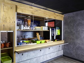 A modern kitchenette with a coffee machine, bread, and condiments. - ibis budget Pontarlier (Pontarlier)